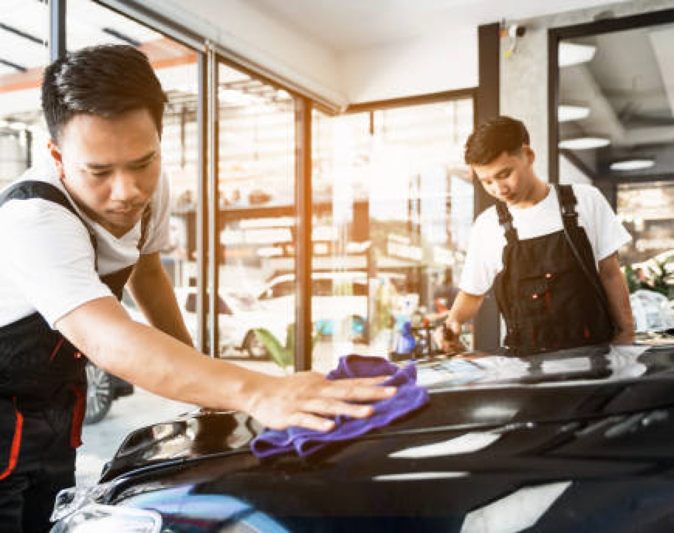 Dealership cleaning service polishing glass displays and entrances